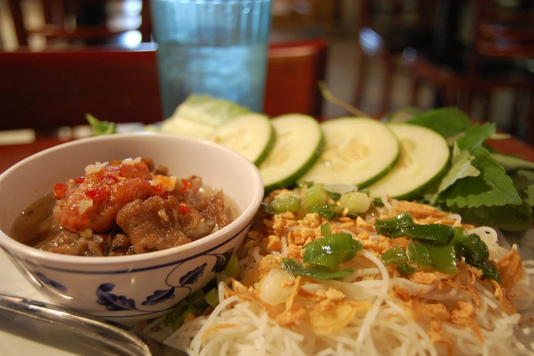 Suất bún chả Hà Nội với bát chả nướng, đĩa bún rối và rổ rau sống