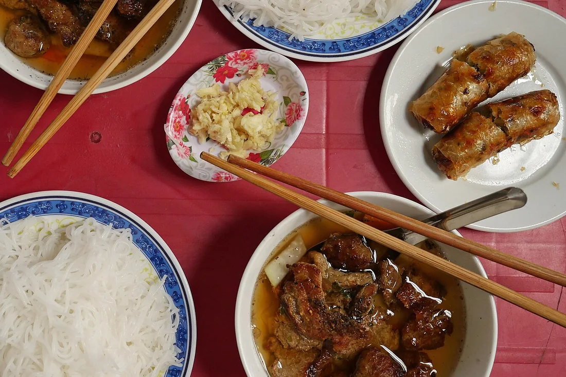 Bát nước chấm bún chả màu hổ phách với đu đủ xanh và cà rốt