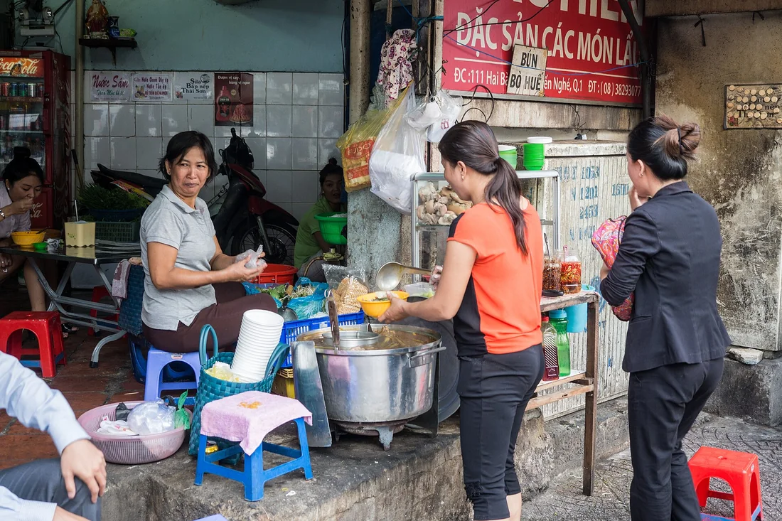 Gánh hàng ăn bên vỉa hè Hà Nội với nồi nước dùng và rổ rau tươi